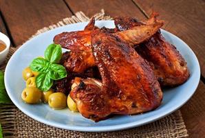 prato de asas de frango em fundo de madeira foto