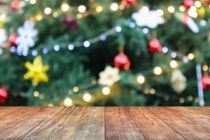 tampo de mesa de madeira vazio com árvore de natal desfocada com fundo claro bokeh foto