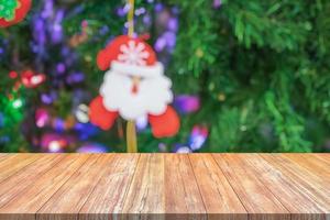 tampo de mesa de madeira vazio com árvore de natal desfocada com fundo claro bokeh foto