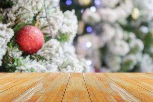 tampo de mesa de madeira vazio com árvore de natal desfocada com fundo claro bokeh foto