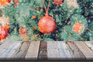 tampo de mesa de madeira vazio com árvore de natal desfocada com fundo claro bokeh foto