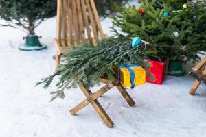 árvores de natal e ramos de abeto para decoração no mercado agrícola para venda na temporada de férias de inverno foto