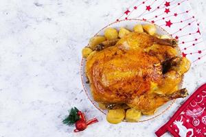 frango assado e batata com decoração de natal. comida tradicional para o natal ou dia de ação de graças foto