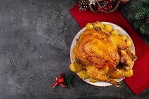 frango assado e batata com decoração de natal. comida tradicional para o natal ou dia de ação de graças foto