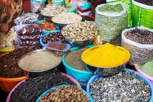 especiarias coloridas indianas no mercado local. uma variedade de especiarias de diferentes cores e tonalidades, sabores e texturas nas bancas do mercado indiano foto