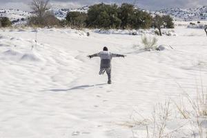 menino correndo e curtindo a paisagem de neve foto