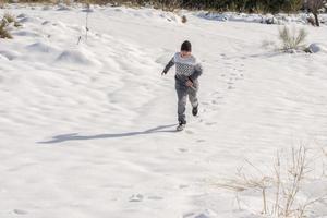 jovem se divertindo correndo na neve grande foto