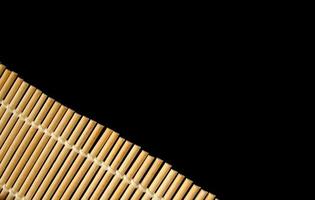 tapete de rolo de bambu para cozinhar sushi em fundo preto. copie o espaço para o texto foto