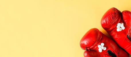 luvas de boxe e pílulas. banner, lugar para texto. drogas e conceito de esportes, anabolizantes e esteróides foto