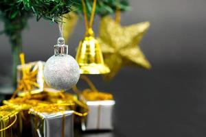 árvore de natal com item decorado pendurado em uma árvore e caixa de presente debaixo da árvore de natal. feliz natal, feliz ano novo e conceito de cartão de felicitações.