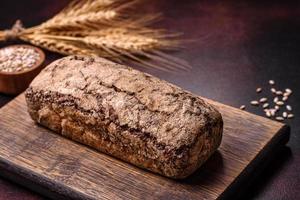 um pedaço de pão integral com grãos de cereais em uma tábua de madeira