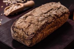 um pedaço de pão integral com grãos de cereais em uma tábua de madeira foto