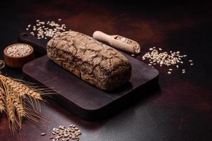 um pedaço de pão integral com grãos de cereais em uma tábua de madeira