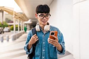 uma foto de um estudante asiático usando um telefone celular