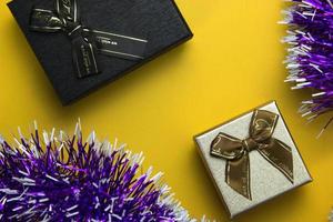 caixas de presente pretas e douradas. objeto festivo decorativo de duas caixas de presente em design de conceito de natal amarelo para pôster, banners, festa de decoração em fundo amarelo. foto