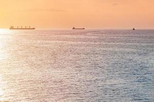 navios de carga e barcaça ao pôr do sol. incrível vista do mar à noite, vista de viagem de tirar o fôlego, copie o espaço. ancoradouro para navios foto