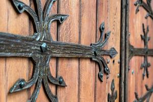 padrão forjado na porta com elementos decorativos. antiga entrada vintage, enorme porta de madeira pesada da igreja ou catedral. foto