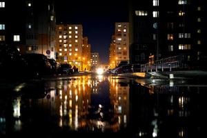 vida noturna, edifícios modernos da capital com o reflexo da luz nas poças. foto