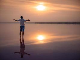 silhueta masculina na praia. uma caminhada ao amanhecer e meditação. foto