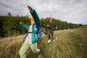 irmãos se divertindo e correndo ao ar livre perto da floresta. foto