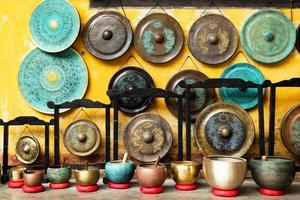 gongos e tigelas de canto - instrumentos musicais tradicionais asiáticos em um mercado de rua. hoi an, vietnã. foto