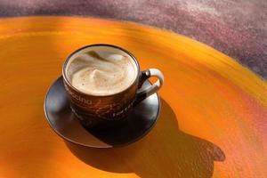xícara com café com leite quente em uma mesa de madeira colorida em um café. Dalat, Vietnã. foto