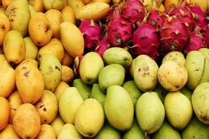 frutas tropicais exóticas - manga, fruta do dragão - closeup em um mercado, vista superior. foto