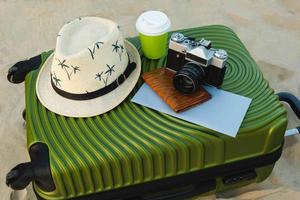 descansar e viajar. uma mala ou saco de bagagem com um chapéu de sol no fundo da praia, bilhetes de avião, óculos de sol, passaporte, férias foto