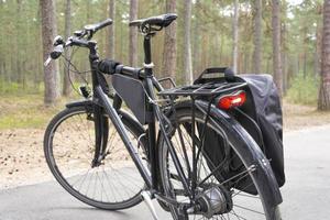 bicicleta estacionada no caminho da floresta, ciclovia na floresta, luz traseira da bicicleta foto