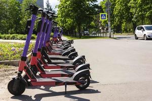 aluguel de scooter elétrico no estacionamento, recreação ativa, vida na cidade, aluguel de scooter elétrico foto