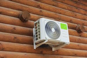 ar condicionado externo na parede de madeira de uma casa particular de toras, clima, esfria, calor, habitação confortável