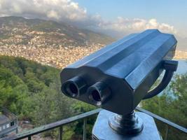 binóculos, luneta para observar a paisagem e pontos turísticos em um deck de observação com vista para a cidade em um resort tropical quente do sul do país oriental foto