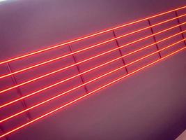 textura de néon brilhante vermelho brilhante levou listras abstratas de laser multicoloridas e linhas de lâmpadas paralelas. o fundo foto