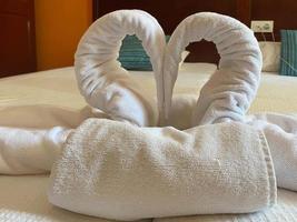 design de interiores de quarto com cisnes da decoração de toalha na cama foto