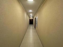 longo corredor com portas de metal, parede e chão lavrados foto