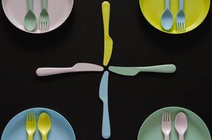 prato colorido com garfo e colher separados um do outro com a faca. foto