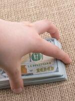 mão segurando o pacote de notas de dólar americano na mão foto