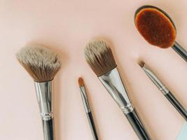 pincéis de maquiagem premium em fundo azul e rosa, cosméticos criativos flat lay, ferramentas para maquiagem, copie o espaço foto