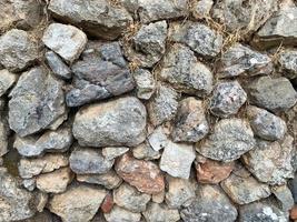 fundo, textura, parede de pedra de pedras redondas paralelepípedos tijolos superfície natural natural afiado convexo pedra áspera calçada com rachaduras foto