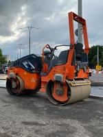 Rolo compactador moderno grande e poderoso laranja para pavimentação asfáltica e reparo de estradas no canteiro de obras. máquinas de construção foto