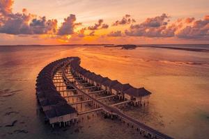 paisagem de praia incrível. bela vista do mar do pôr do sol das maldivas. horizonte colorido mar céu nuvens, sobre a água villa cais caminho. lagoa tranquila da ilha, fundo de viagens de turismo. férias exóticas