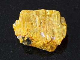 pedra orpiment nativa crua em fundo escuro foto