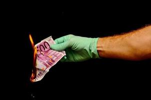 mão segurando a queima de dinheiro em euros foto