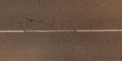 vista panorâmica de cima na textura da superfície da velha estrada de asfalto com rachaduras foto