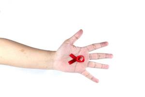 símbolo de mão com fita vermelha, significando preocupação com pessoas com aids hiv isoladas no fundo branco foto