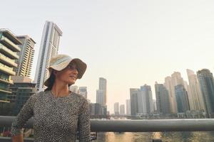 dubai, emirados árabes unidos, 2022 - bela turista caucasiana em vestido de verão da moda desfruta da marina de dubai nos emirados árabes unidos. temporada de turismo de luxo e confortável foto