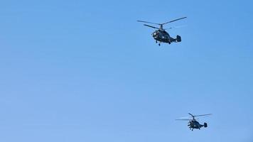 dois helicópteros militares voando no céu azul vibrante realizando voo de demonstração, show aéreo foto