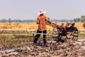 agricultor dirige um arado em um campo. foto