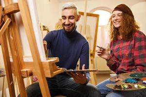 casal estiloso sorrindo e pintando foto