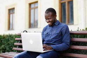 homem rindo enquanto trabalha no computador foto